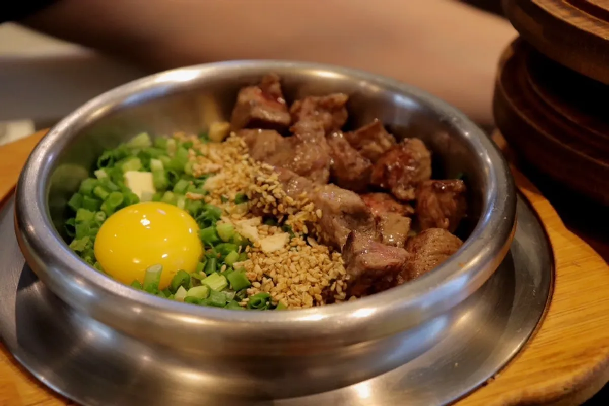 Pot rice topped with thickly sliced steak