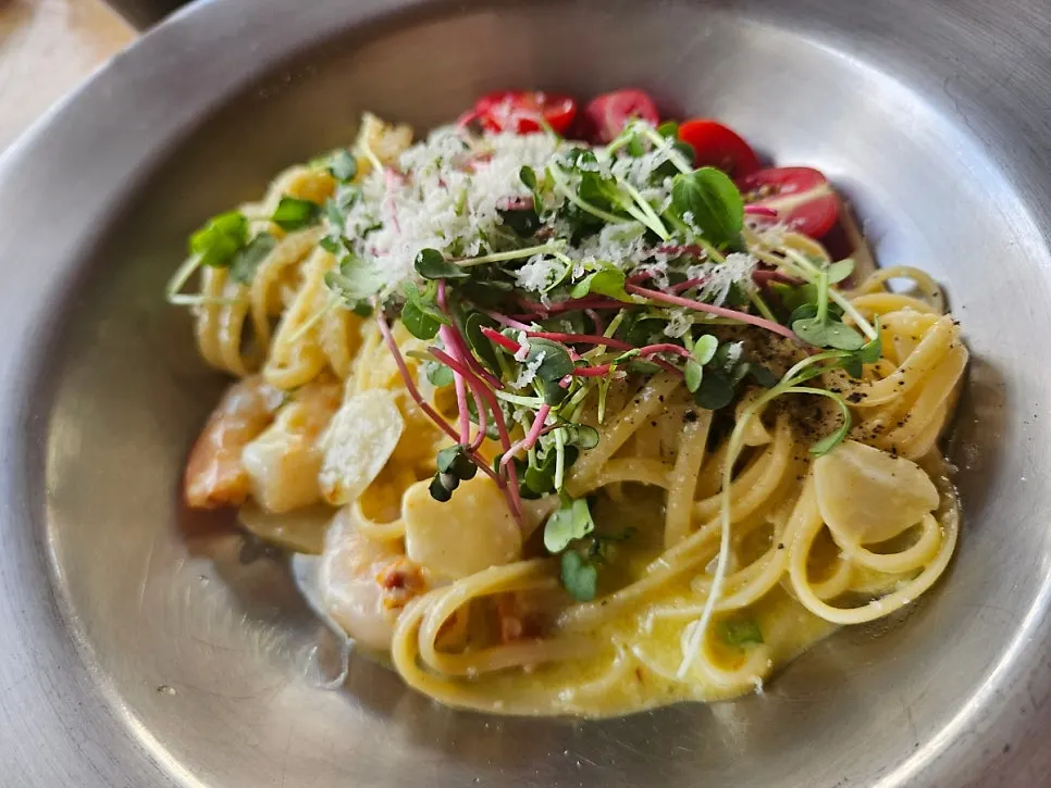 Aglio olio topped with sprouts and shrimp