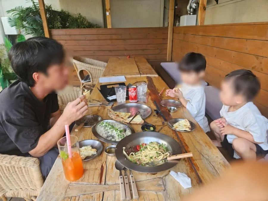 A family meal scene at the outdoor seating with children