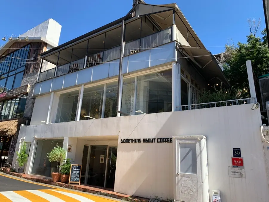 All-white standalone building of Something About Coffee