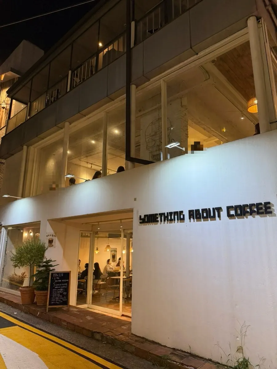 노란 조명이 켜진 썸띵어바웃커피 3층 건물 외관