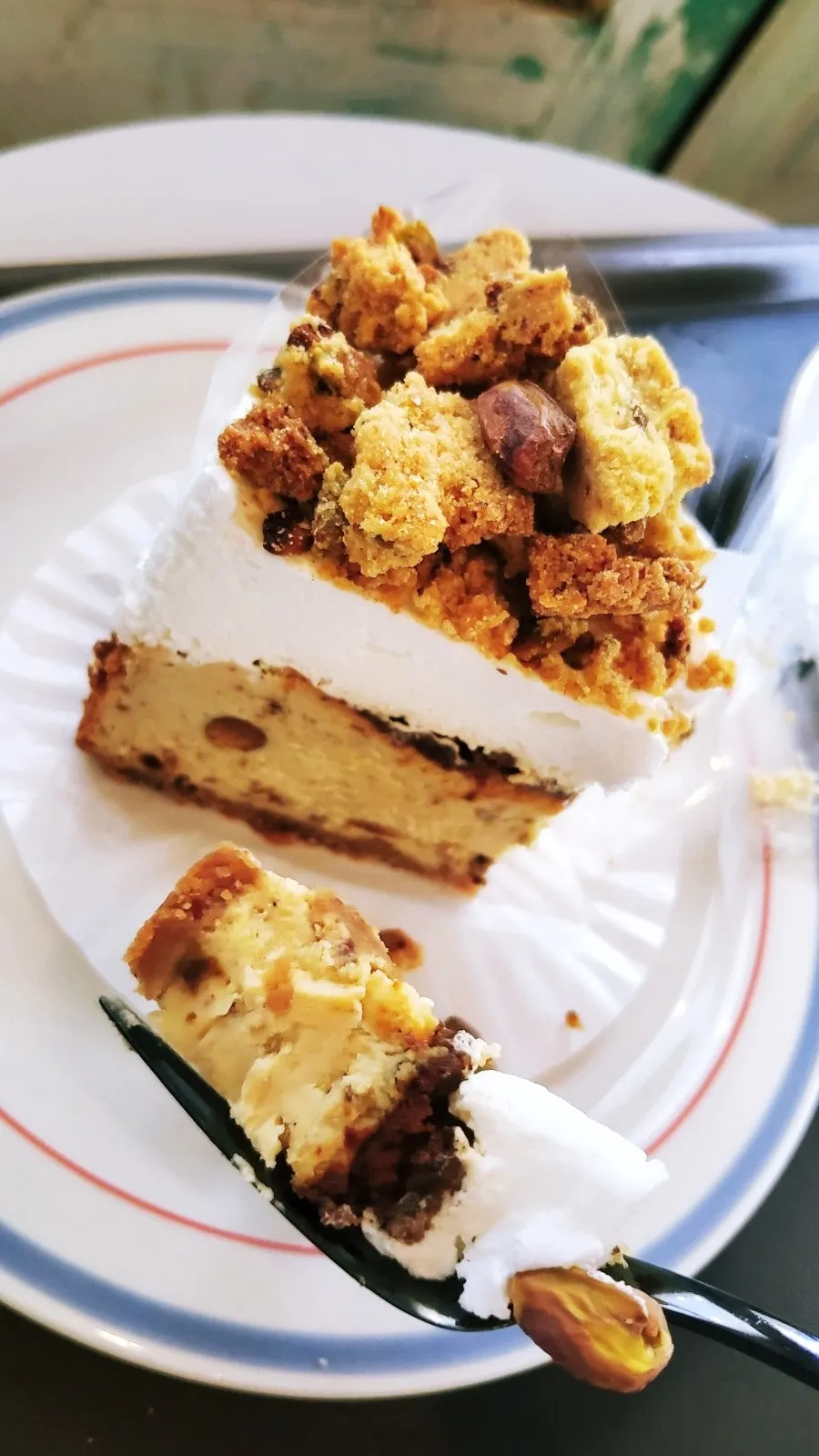 Cross-section of cheesecake topped with crumble and pistachios