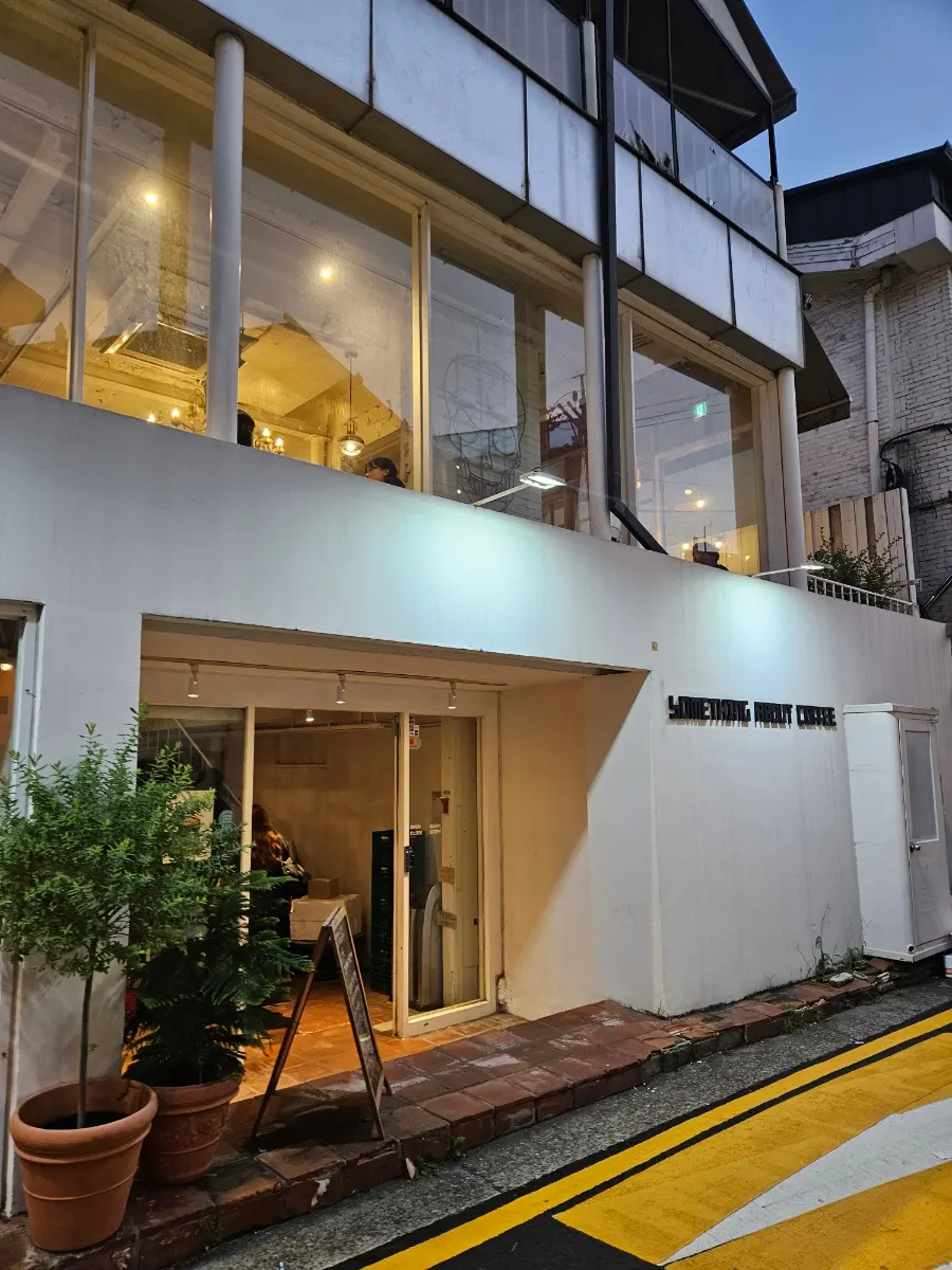 White exterior of Something About Coffee in an alley off Gangnam-daero