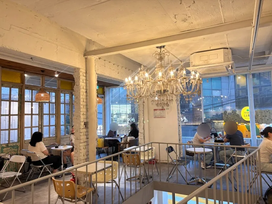Second-floor seating with high ceilings and chandelier lighting