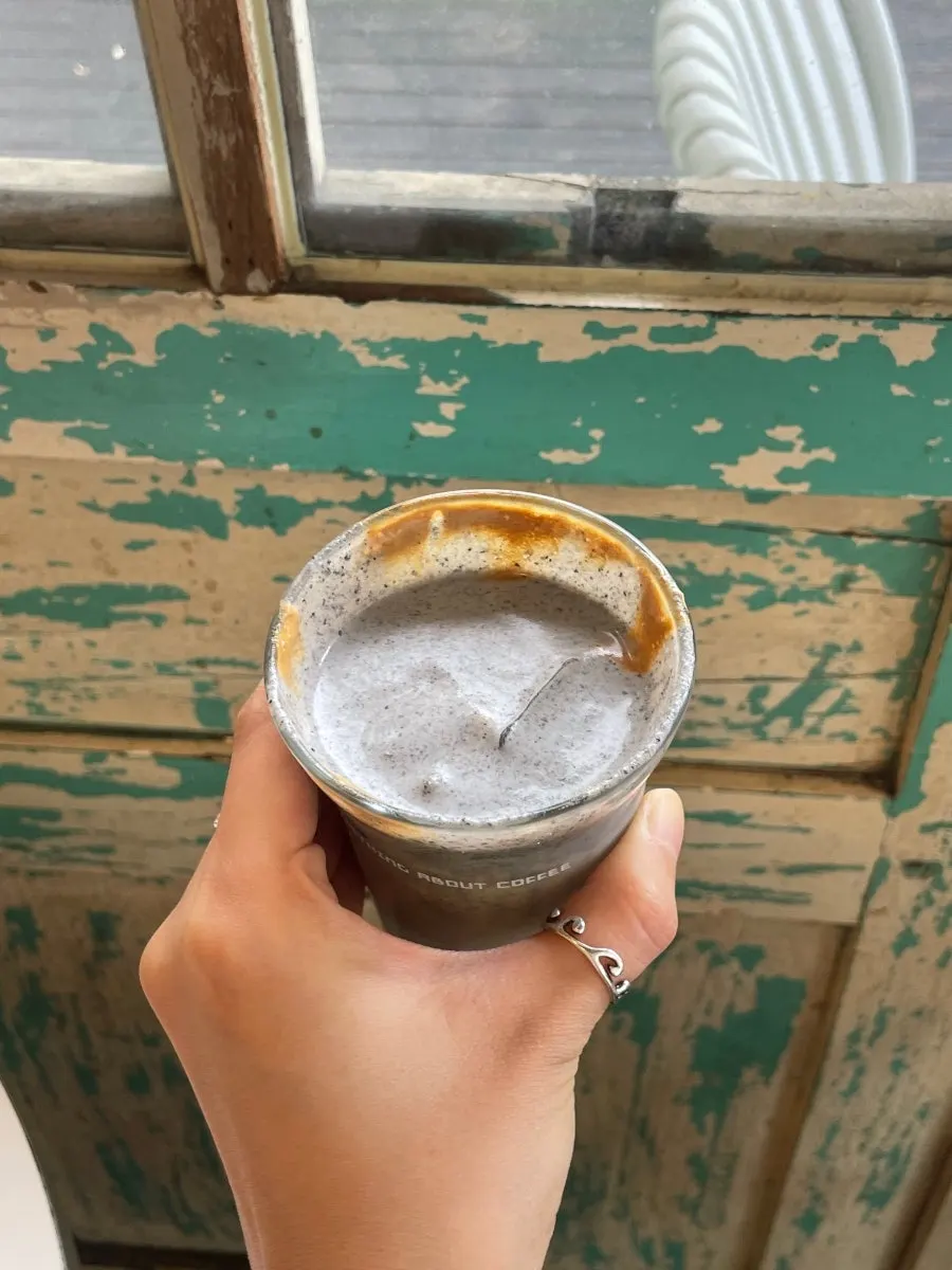 A cup of black sesame cream latte topped with cream