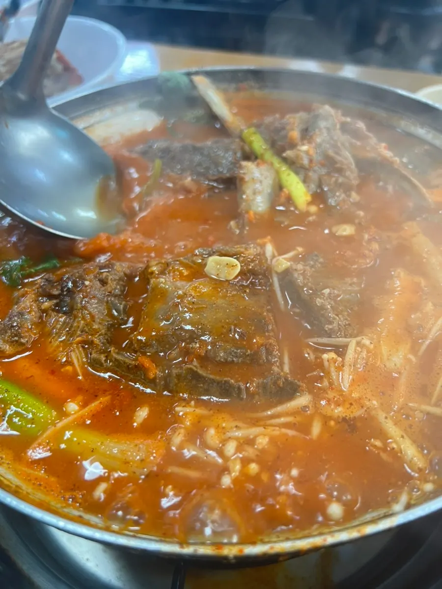 끓고 있는 감자탕 국물과 들깨가루