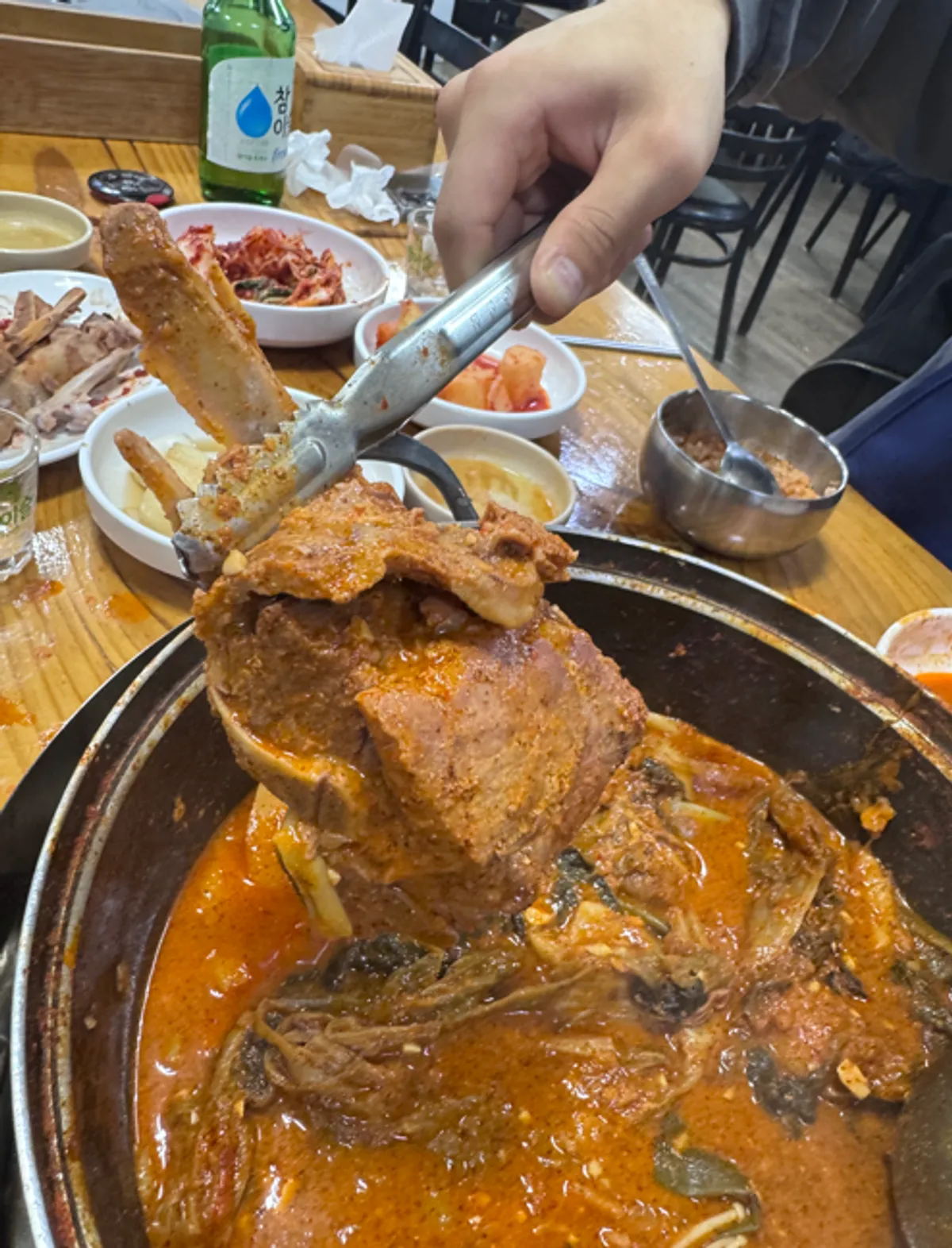 A bottle of soju and beer paired with gamjatang