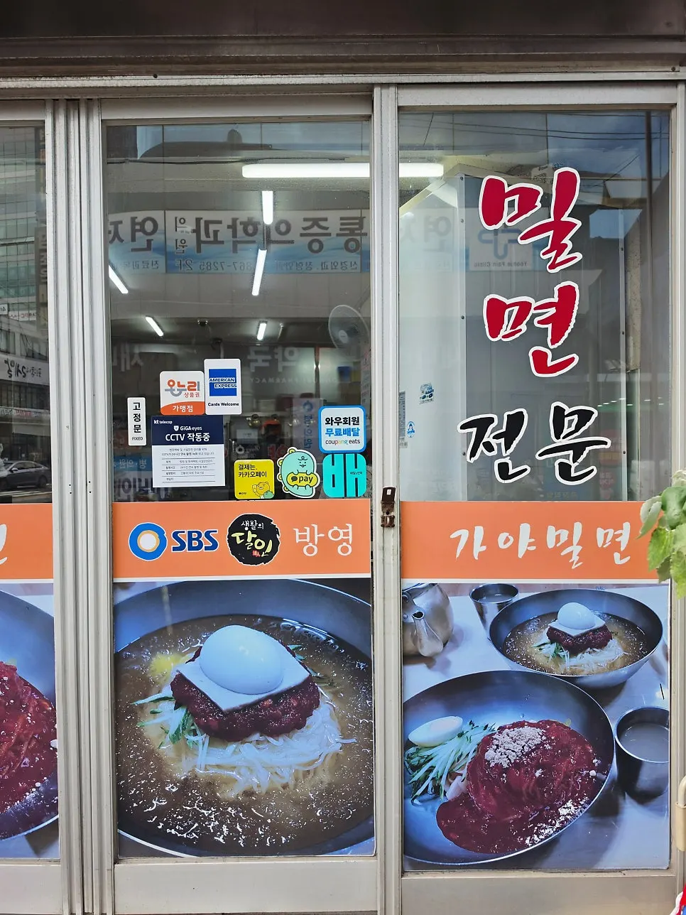 Storefront sign announcing 25 years of handmade noodles