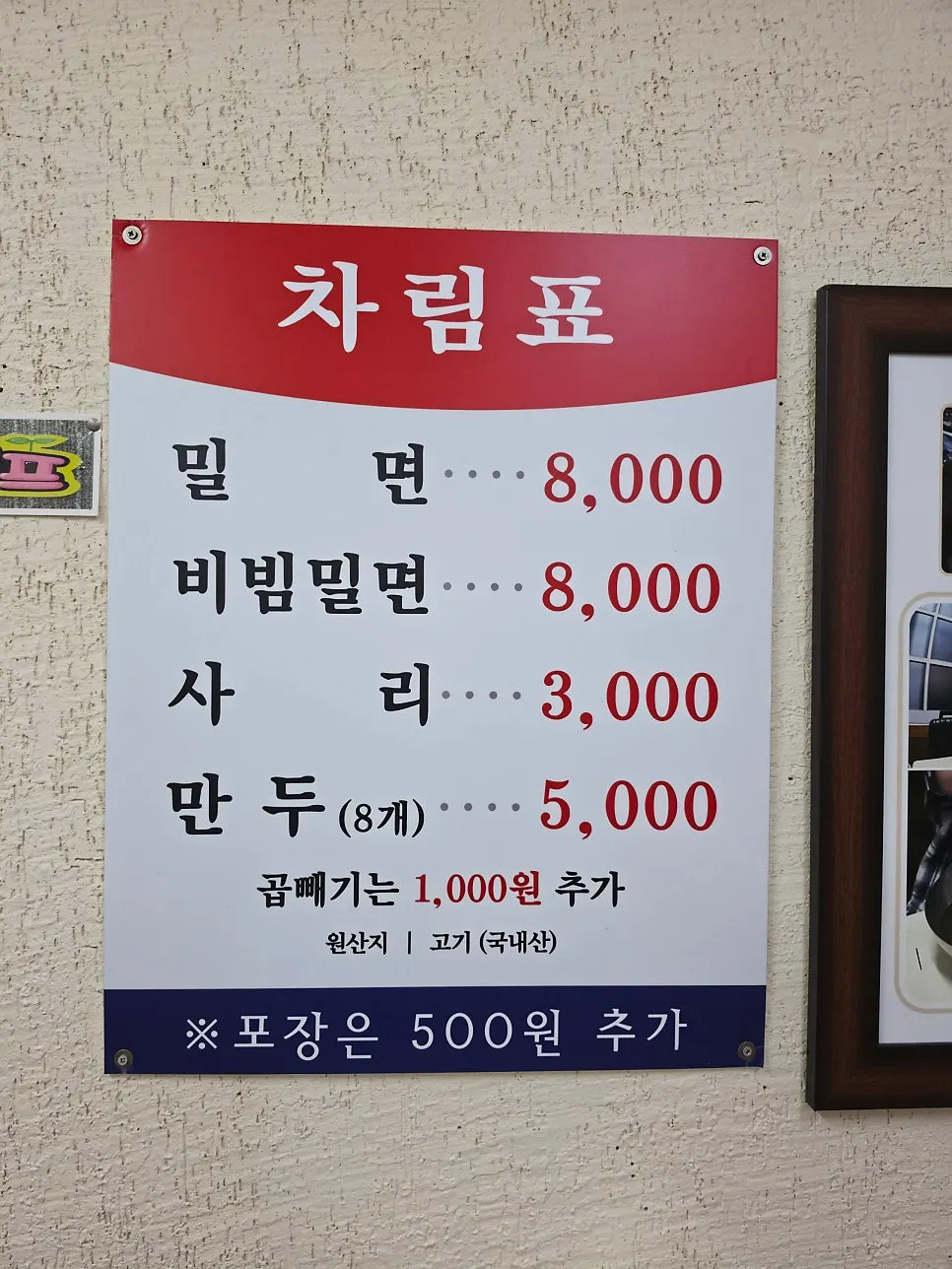 Menu board listing milmyeon, bibim milmyeon, and dumplings