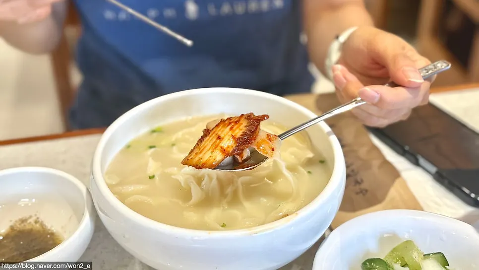 A generous bowl of chicken kalguksu broth and noodles