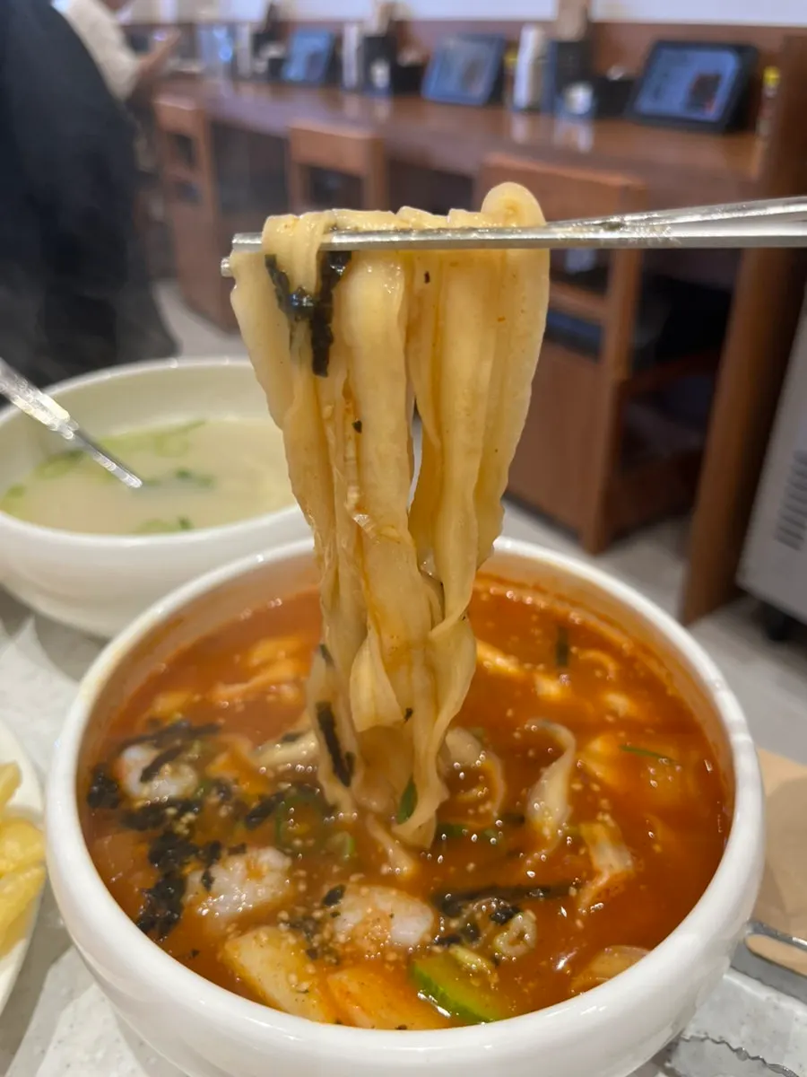 Thick fresh noodles lifted with chopsticks