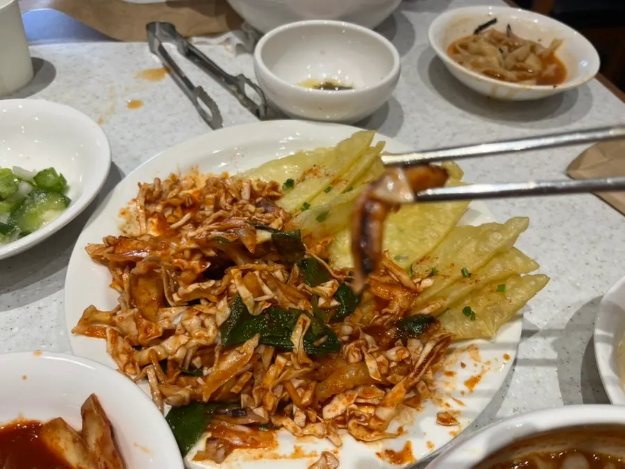 Spicy squid and vegetables piled on flat dumplings