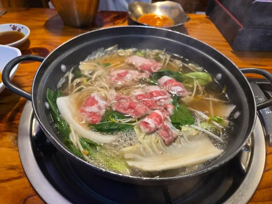 Hot pot simmering with mixed vegetables added