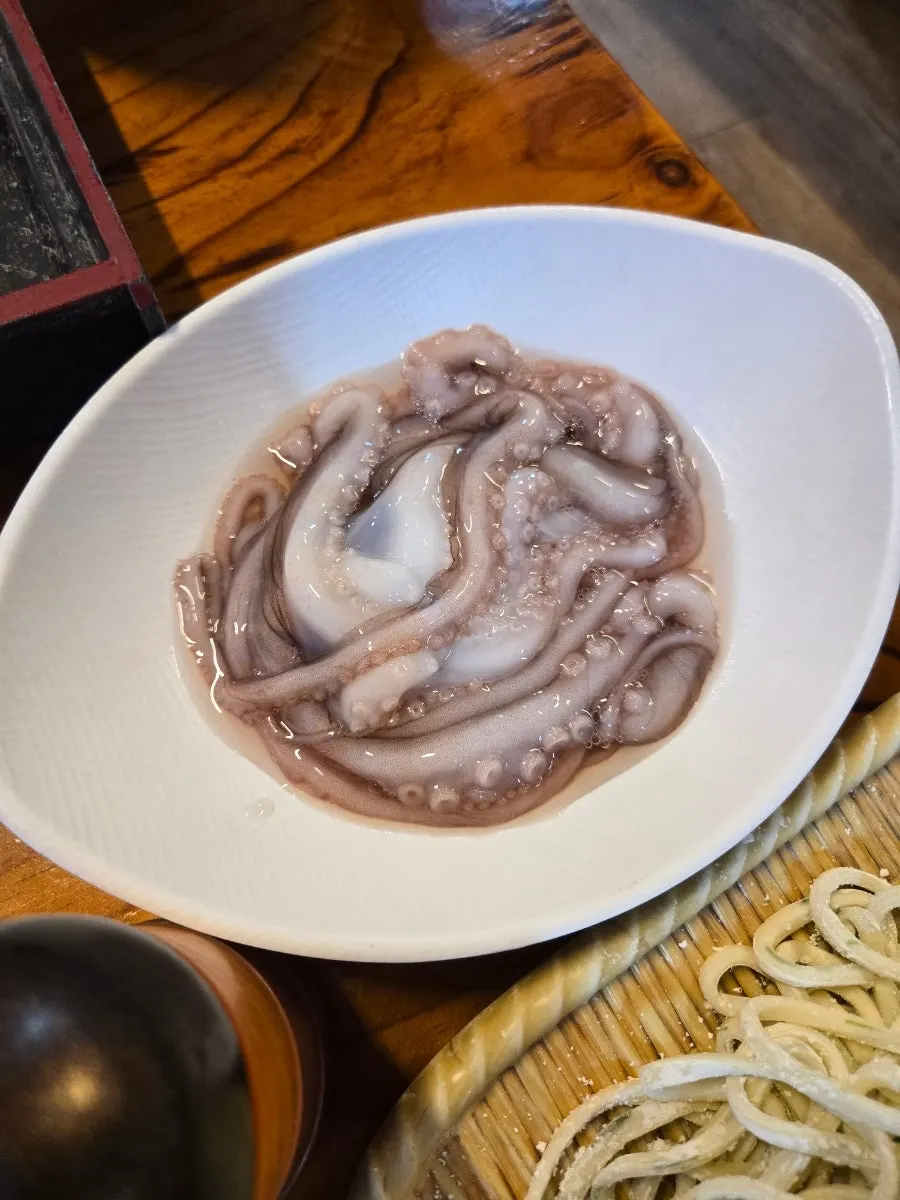 Whole raw octopus served at the table
