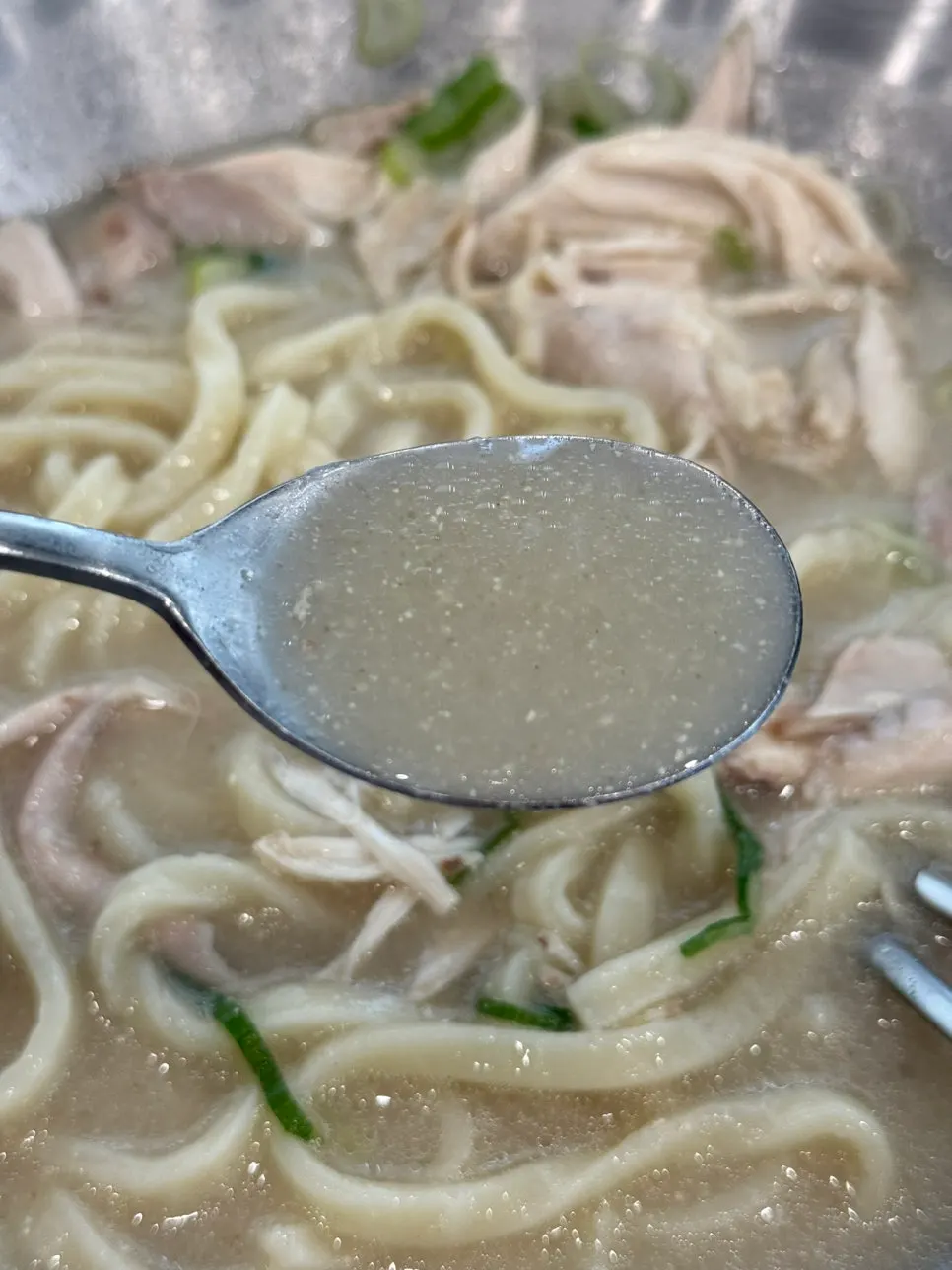 Dak kalguksu broth and chicken sprinkled with black pepper