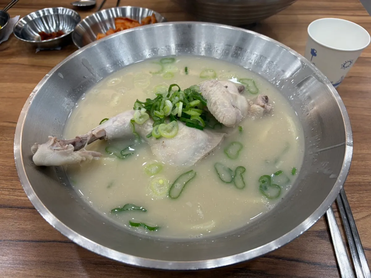 A bowl of chicken kalguksu with half a chicken