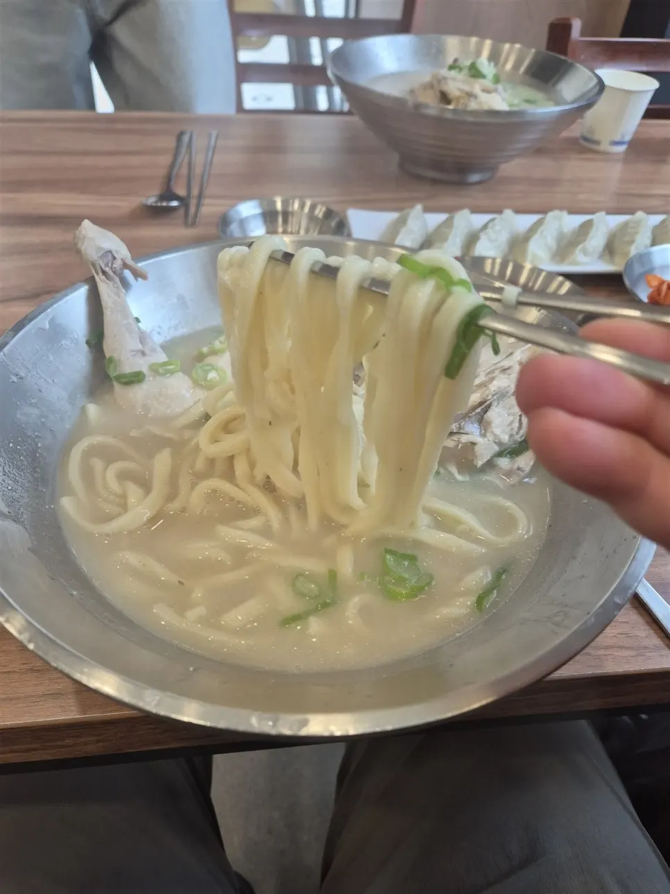 Thick kalguksu noodles lifted up with chopsticks