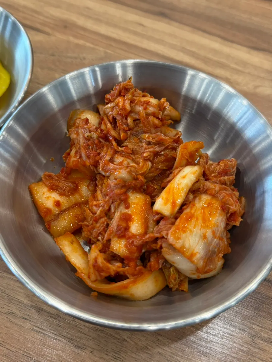Self-serve side dish bar with spicy kimchi and pickled radish