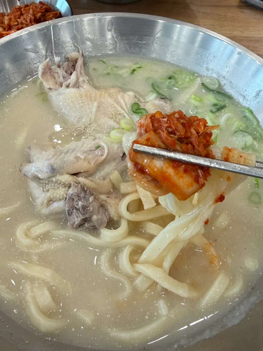 Chewy kalguksu noodles lifted with chopsticks