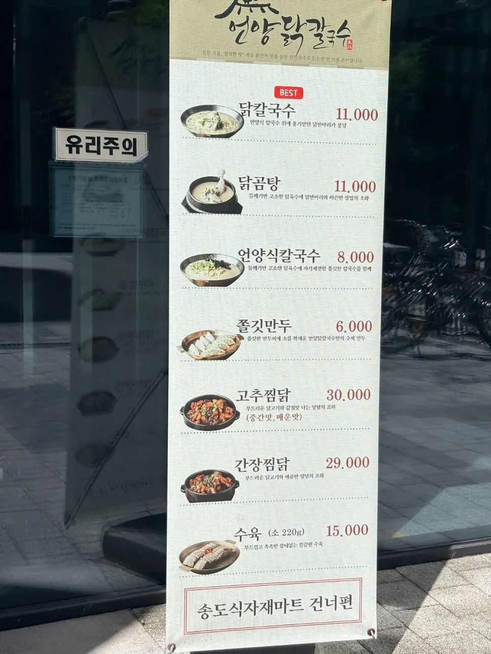 Chicken kalguksu menu board standing at the entrance