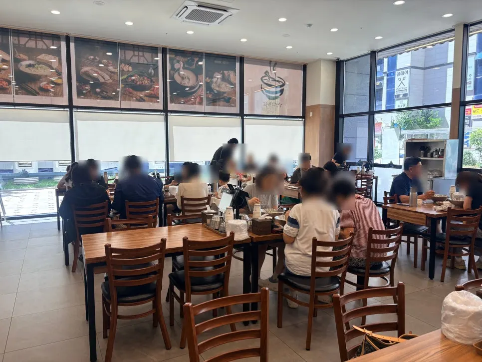Dining hall seating with high ceilings and full-length windows