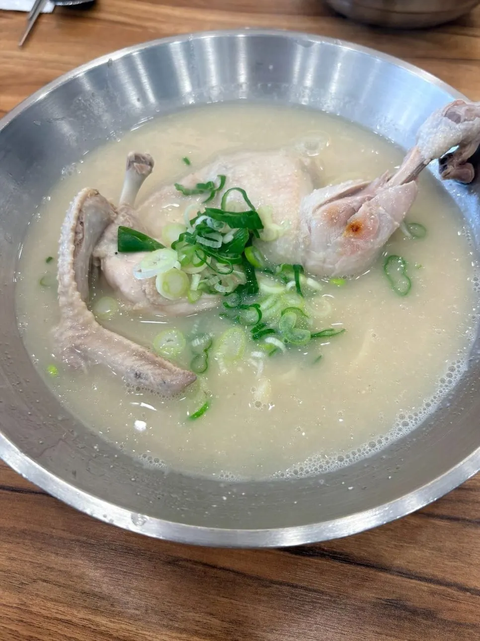 A bowl of chicken kalguksu topped with half a chicken