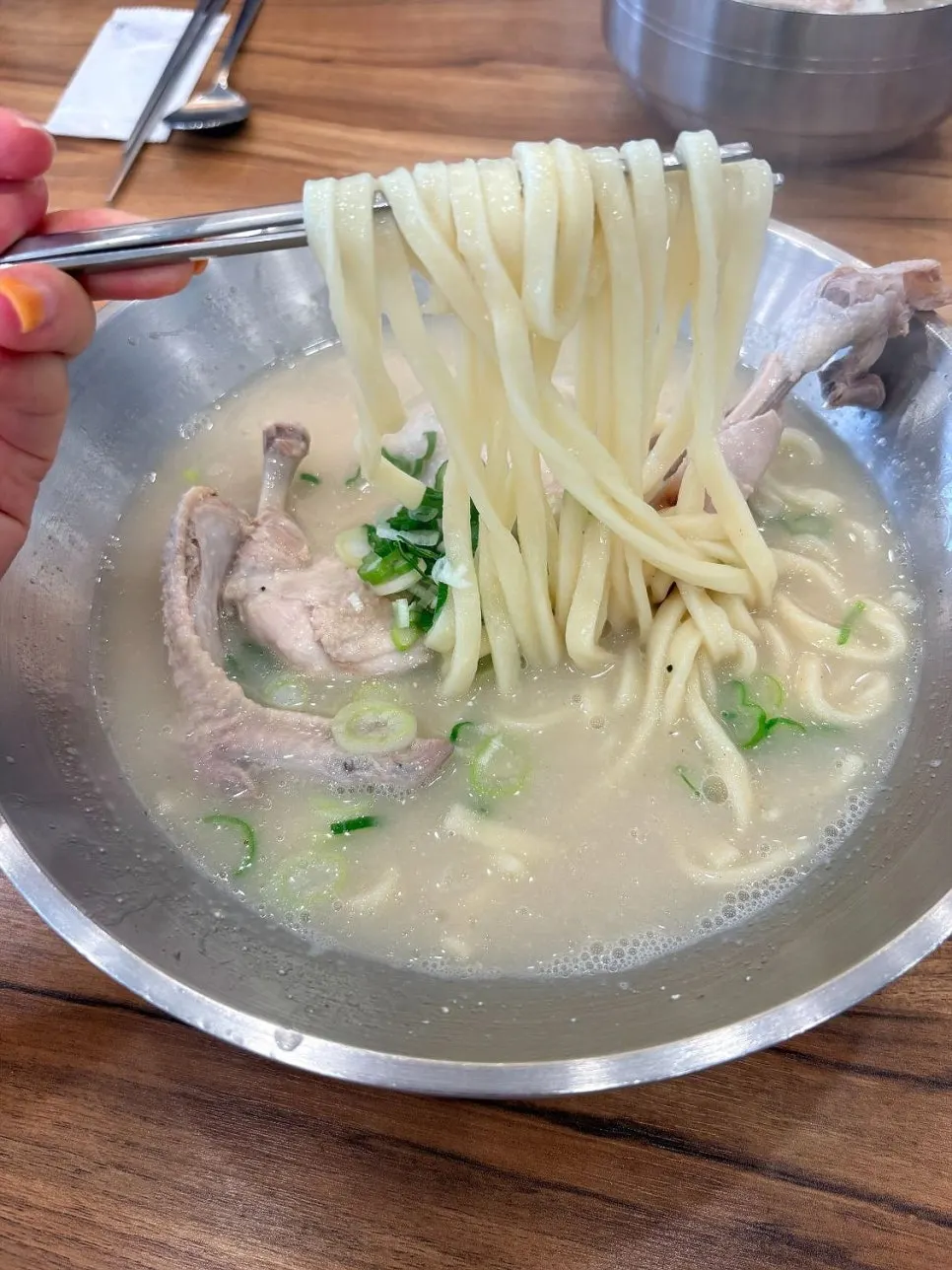 House-made kalguksu noodles lifted with chopsticks
