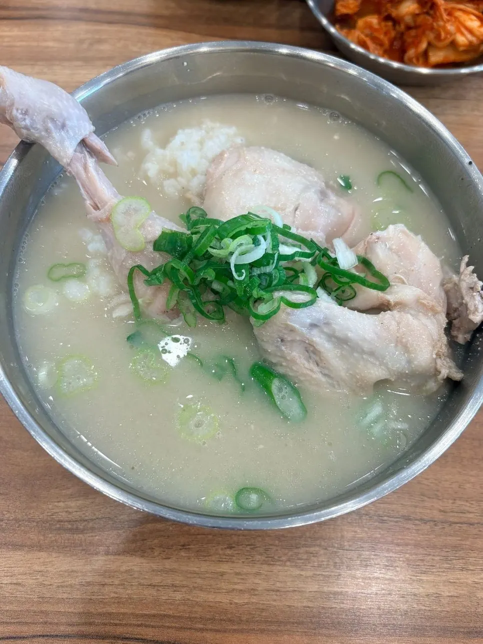 A bowl of chicken gomtang served with rice mixed in