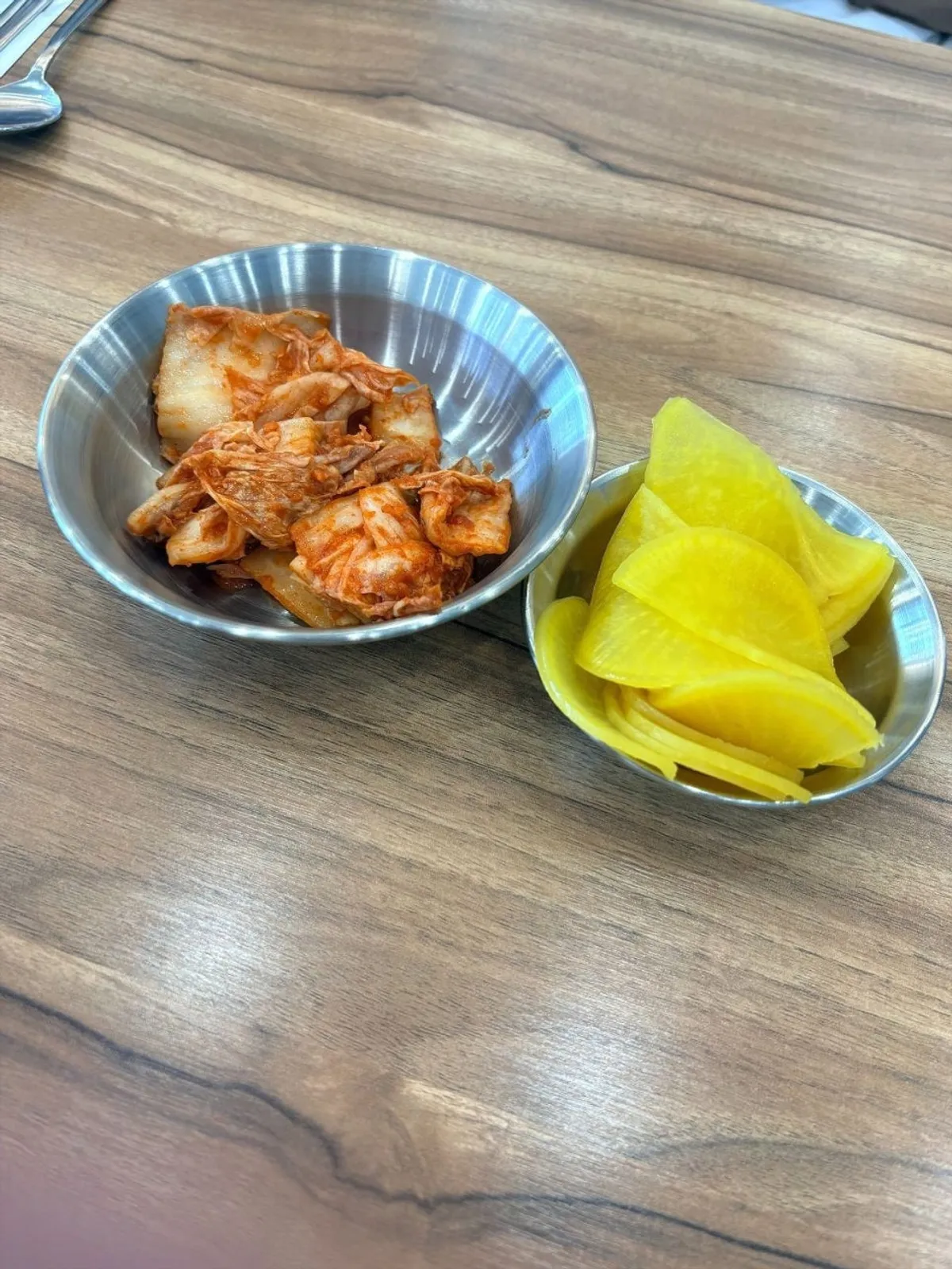 Regular kimchi, spicy kimchi, and pickled radish at the self-serve bar