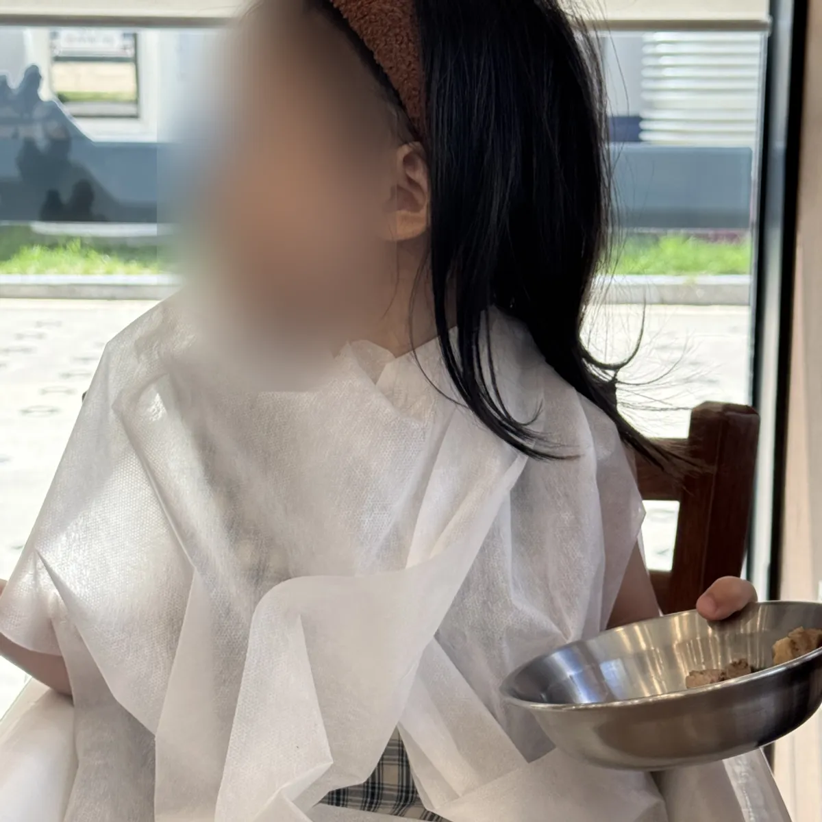 A child holding boiled pork while eating