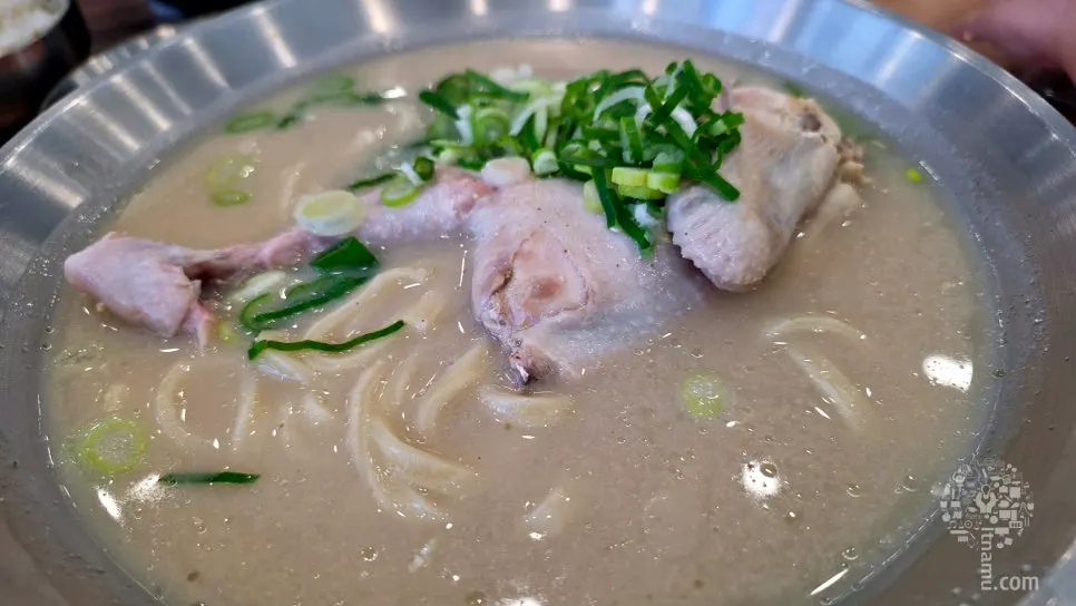 Chewy kalguksu noodles lifted with tongs