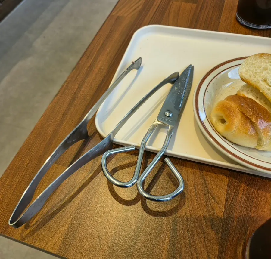접시에 담긴 플레인 소금빵과 가위