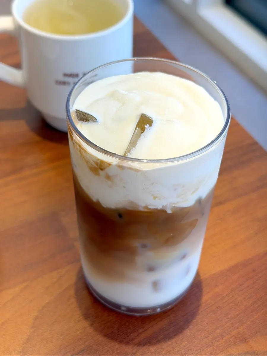 Iced vanilla bean cream latte topped with generous cream