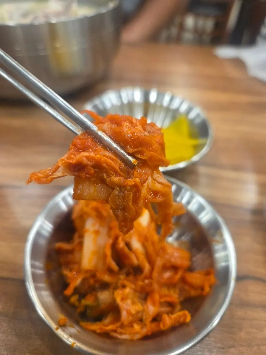 A plate of spicy kimchi and pickled radish brought to the table