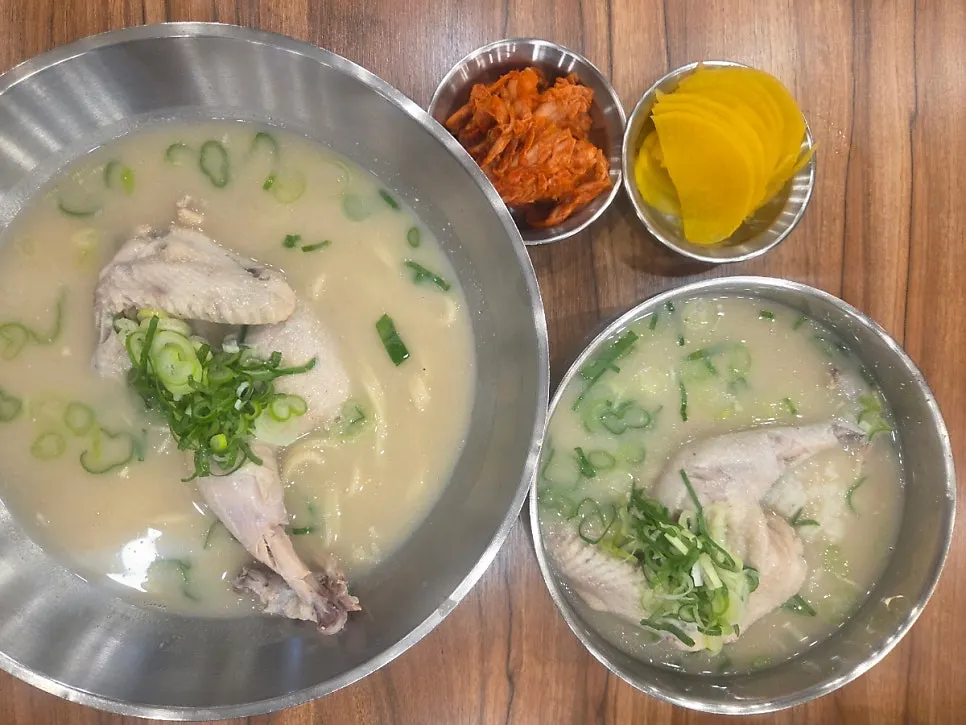 A bowl full of chicken and green onion in chicken broth