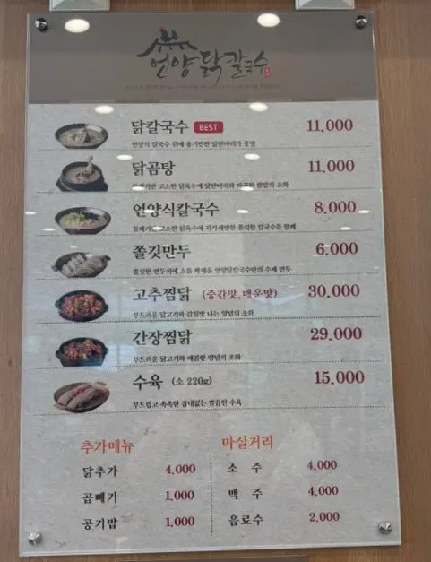 Wall-mounted menu board listing dak kalguksu and dak gomtang prices