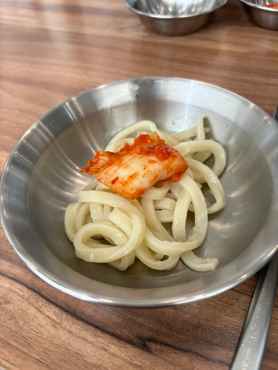 Bowl of chicken kalguksu partway through the meal