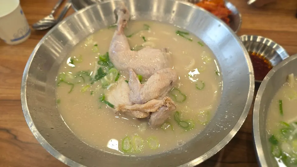 Spoonful of dak kalguksu broth lifted from the bowl