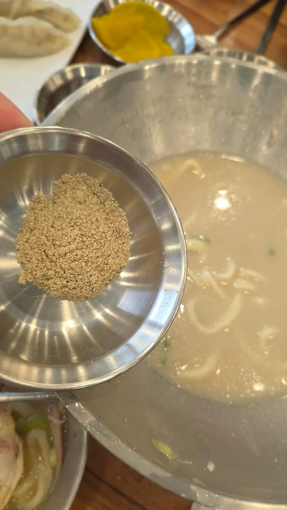 Dak kalguksu broth with added perilla powder