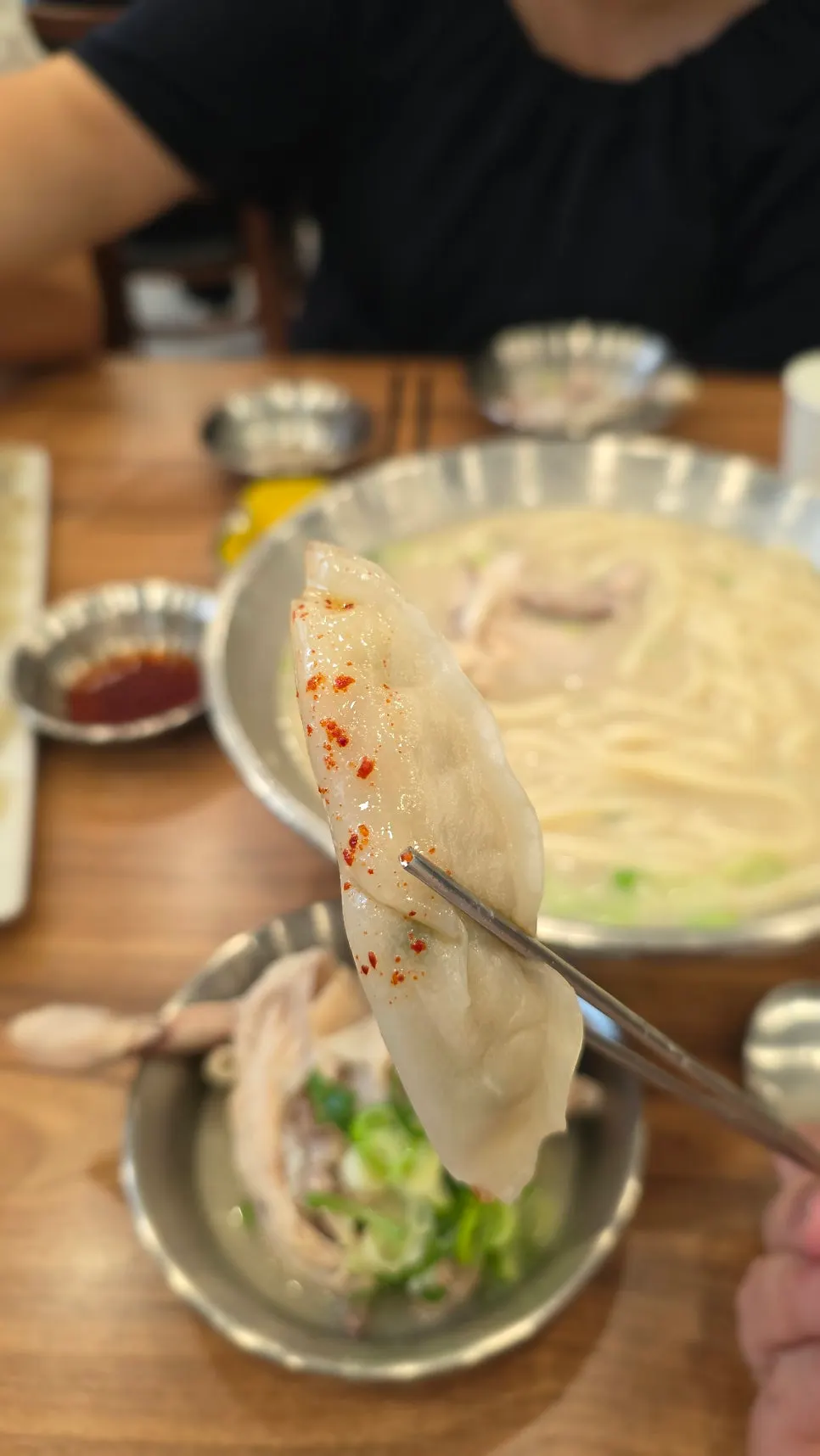 A bite of dumpling paired with the kalguksu