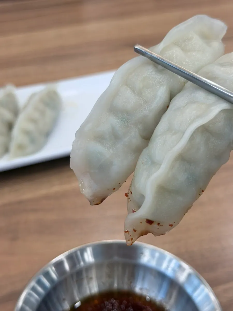 A dumpling cut in half showing the meat and vegetable filling