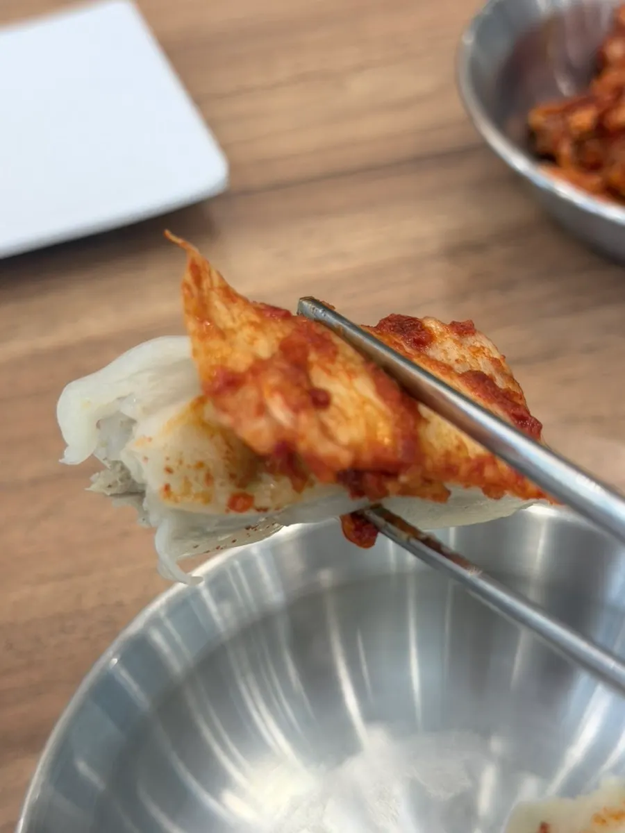 A dumpling dipped into the kalguksu broth