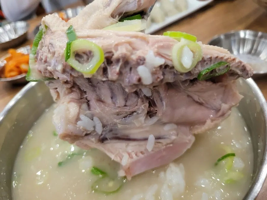A spoonful of chicken kalguksu broth lifted up