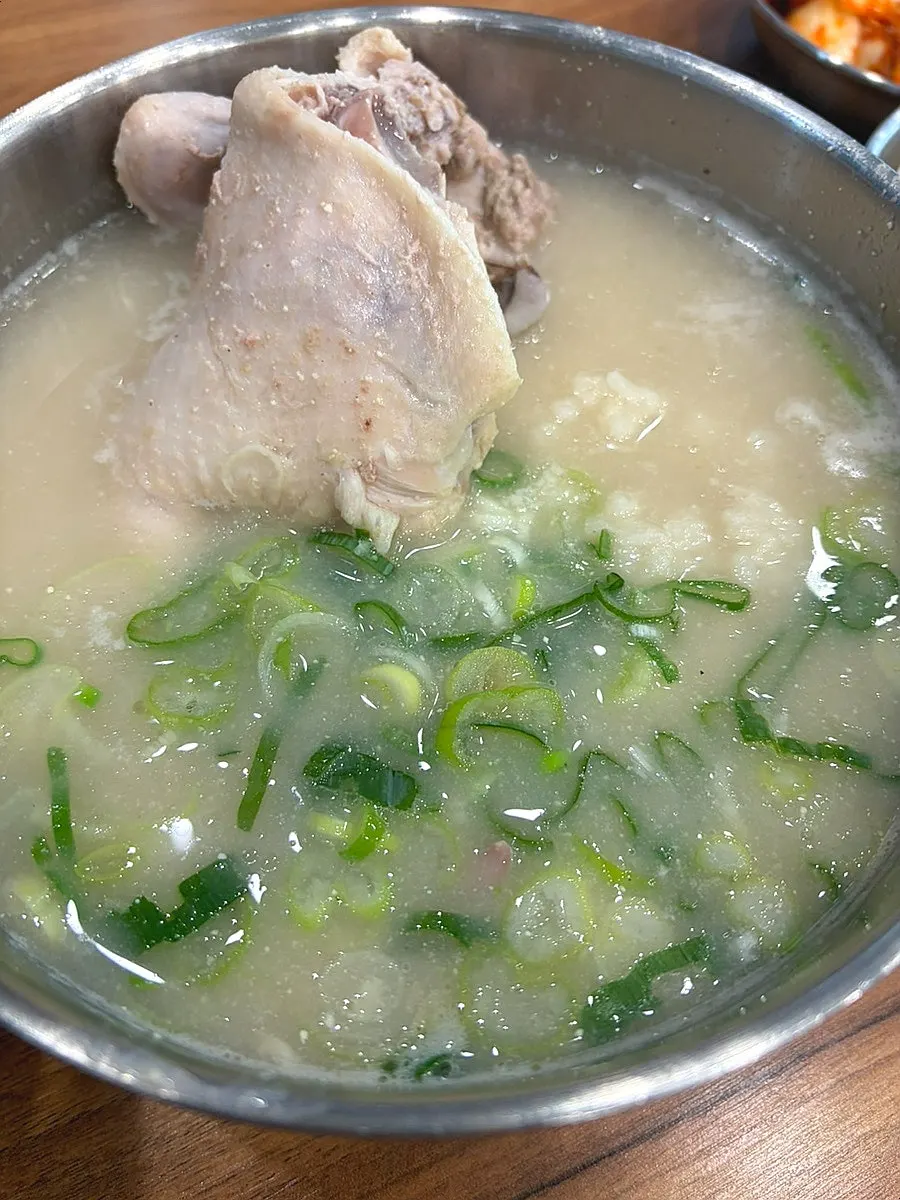 A bite of dak kalguksu topped with napa cabbage kimchi