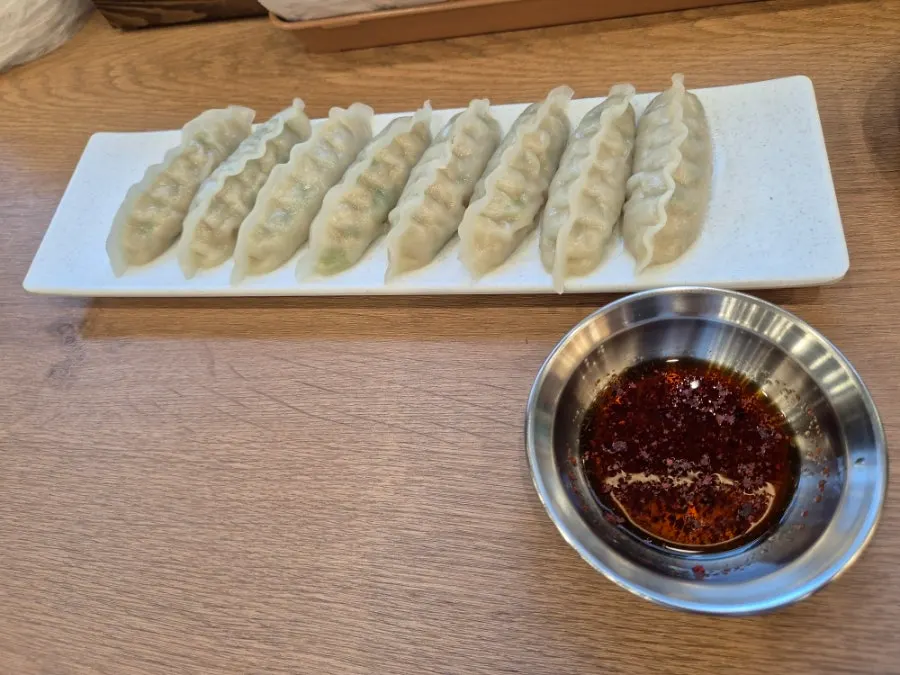 A steamed dumpling cut in half showing the filling
