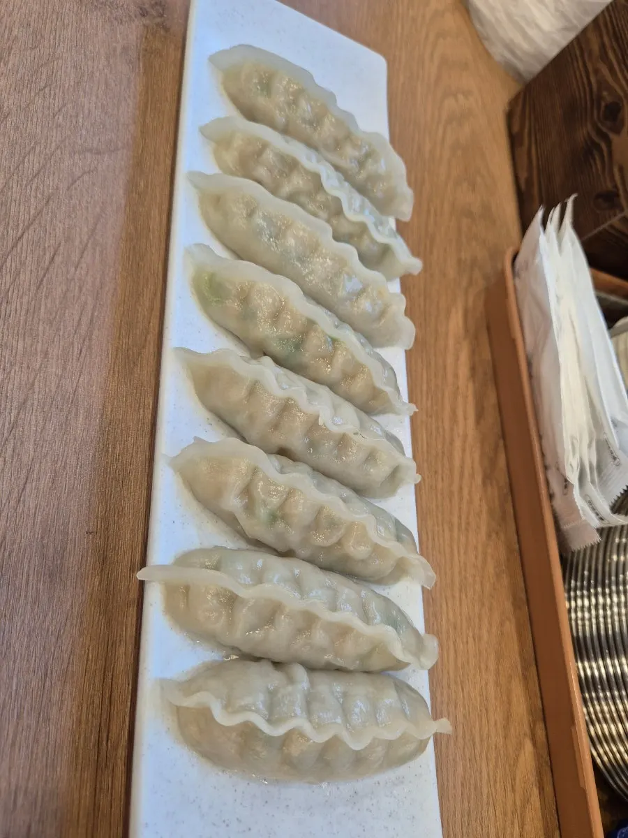 A steamed dumpling dipped in kalguksu broth
