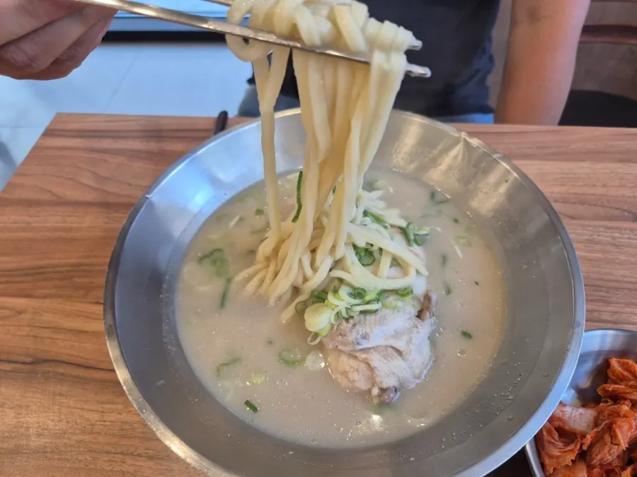 A bowl of Eonyang chicken kalguksu topped with half a chicken