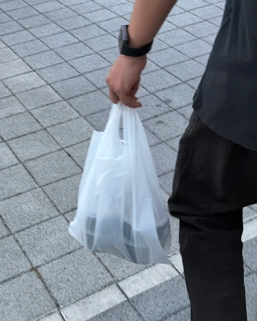 White takeaway bag holding the remaining curries