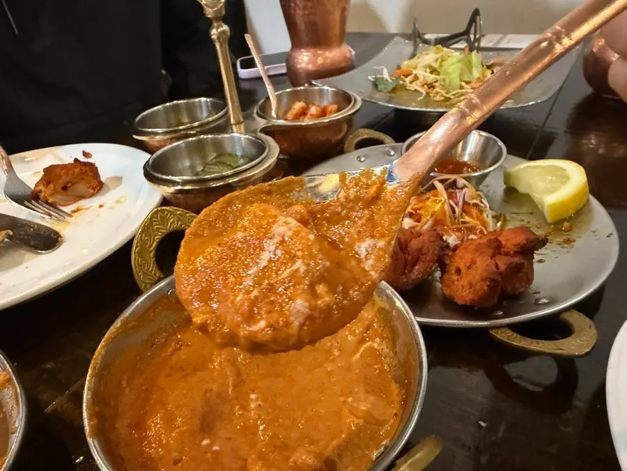 Garlic naan dipped into curry