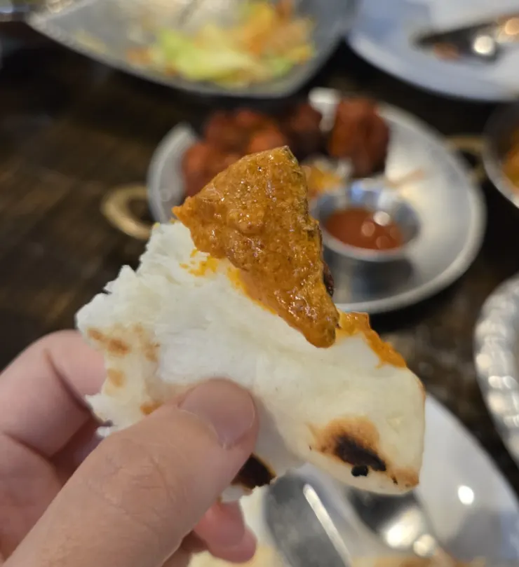 갈릭난을 찢어 치킨커리에 찍는 모습